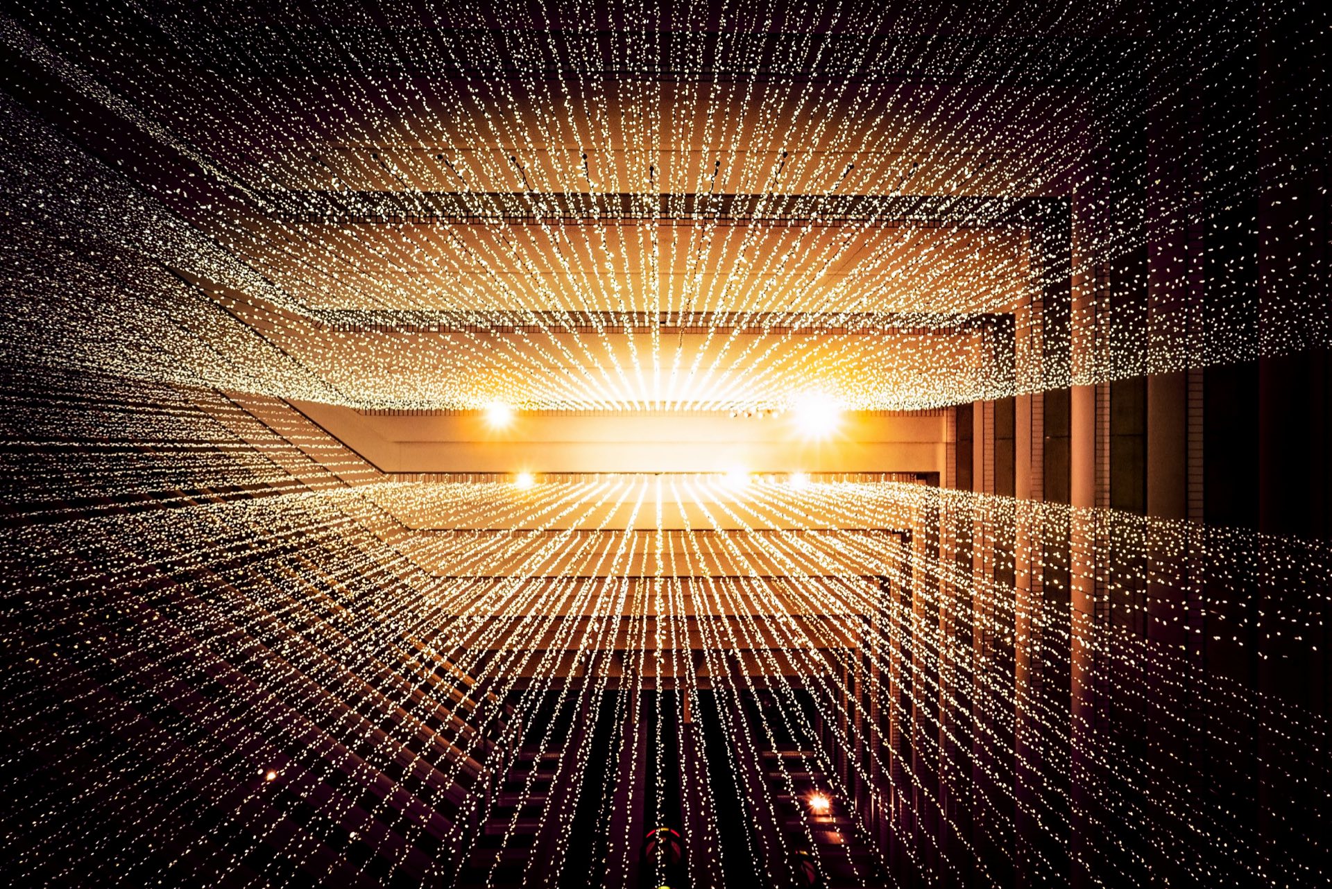 An architectural lattice of thousands of small lights receding into the distance
